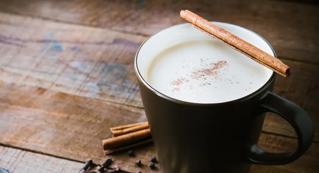 Warme Gewürzmilch mit Zimt in einer Tasse
